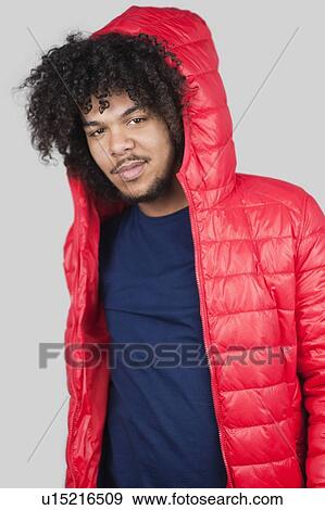 Portrait of young man wearing red jacket with hood over colored background View Large Photo Image Stock Photo - Portrait of young man wearing red jacket with hood over colored background. Fotosearch