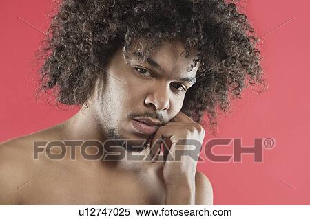 Portrait of young man with hand on chin over colored background View Large Photo Image Stock Photography - Portrait of young man with hand on chin over colored background. Fotosearch