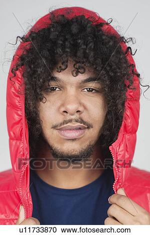 Portrait of young man with hooded jacket over colored background View Large Photo Image Stock Image - Portrait of young man with hooded jacket over colored background. Fotosearch