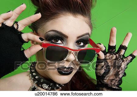 Portrait of young punk woman wearing sunglasses over green background View Large Photo Image Stock Photograph - Portrait of young punk woman wearing sunglasses over green background. Fotosearch