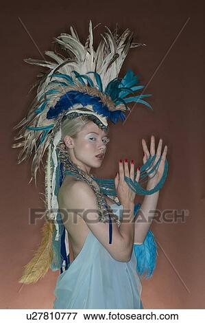 Portrait of young woman in feathered outfit over colored background View Large Photo Image Stock Photo - Portrait of young woman in feathered outfit over colored background. Fotosearch