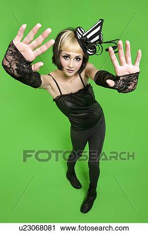 Portrait of young woman posing with fingerless gloves and headdress over green background View Large Photo Image Stock Image - Portrait of young woman posing with fingerless gloves and headdress over green background. Fotosearch