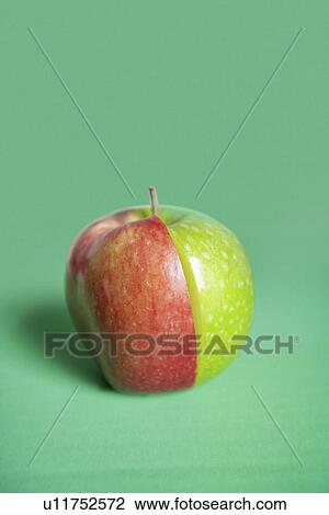 Stock Image - Red and green apple slices joined together over colored background. Fotosearch