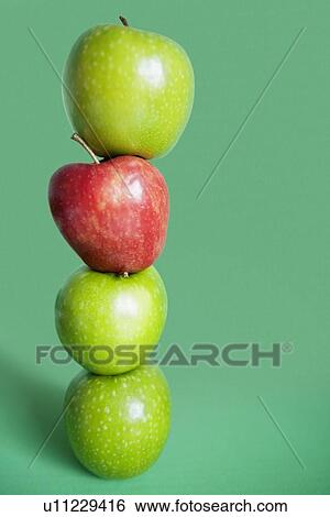 Red and green apples balancing over colored background View Large Photo Image Stock Photograph - Red and green apples balancing over colored background. Fotosearch