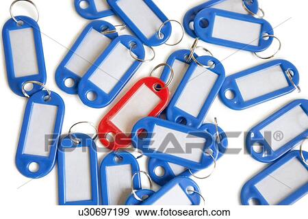 Stock Photo - Red tag ring with blue key rings over colored background. Fotosearch