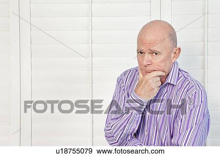 Stock Photo - Senior man in pensive mood with hand on chin. Fotosearch