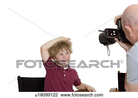 Senior photographer clicking school kid sitting on chair over white background View Large Photo Image Stock Image - Senior photographer clicking school kid sitting on chair over white background. Fotosearch