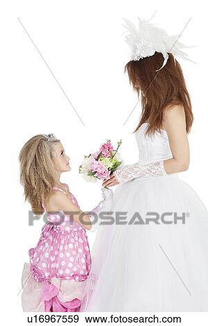 Side view of bride and bridesmaid looking at each other while holding bouquet over white background View Large Photo Image Stock Photo - Side view of bride and bridesmaid looking at each other while holding bouquet over white background. Fotosearch
