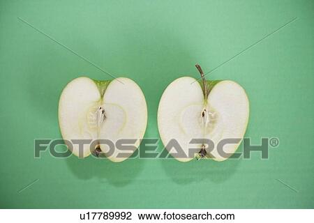Stock Image - Sliced green apple over green background. Fotosearch