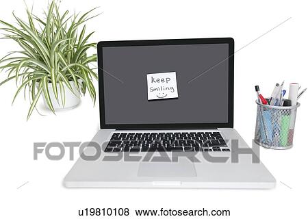 Smiley face sticky note on laptop with office supplies and pot plant View Large Photo Image Stock Photo - Smiley face sticky note on laptop with office supplies and pot plant. Fotosearch