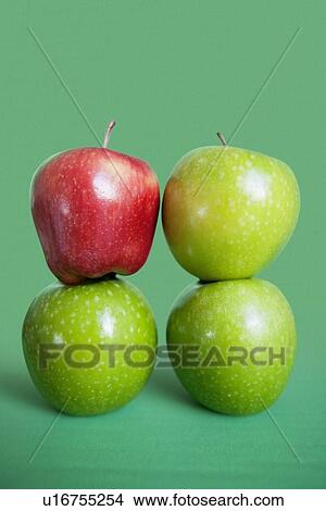 Picture - Stack of red and green apples over colored background. Fotosearch