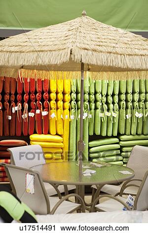Stock Image - Sunshade with table and chair in store. Fotosearch