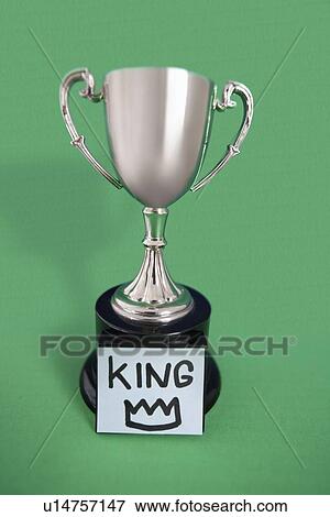 Stock Photo - Trophy with sticky note over colored background. Fotosearch