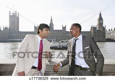 Stock Photo - Two multi ethnic businessmen having a conversation. Fotosearch