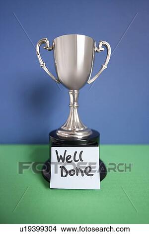 Winning trophy award with sticky note over colored background View Large Photo Image Picture - Winning trophy award with sticky note over colored background. Fotosearch