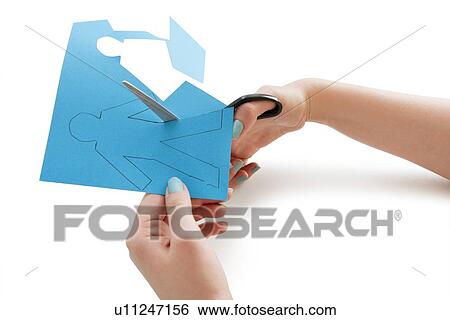 Stock Photograph - Woman's hand cutting a paper stick figure over white background. Fotosearch