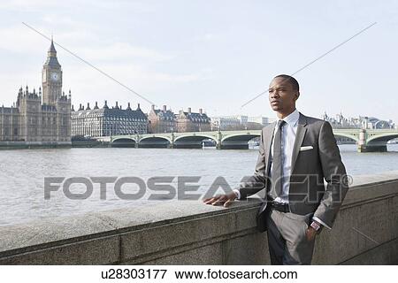 Young African American businessman looking away with hand in pocket View Large Photo Image Stock Photo - Young African American businessman looking away with hand in pocket. Fotosearch