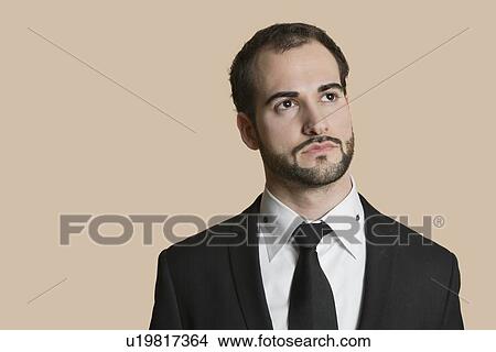 Young businessman looking away over colored background View Large Photo Image Picture - Young businessman looking away over colored background. Fotosearch