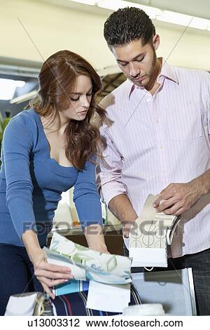 Young couple looking at textile samples in store View Large Photo Image Stock Image - Young couple looking at textile samples in store. Fotosearch
