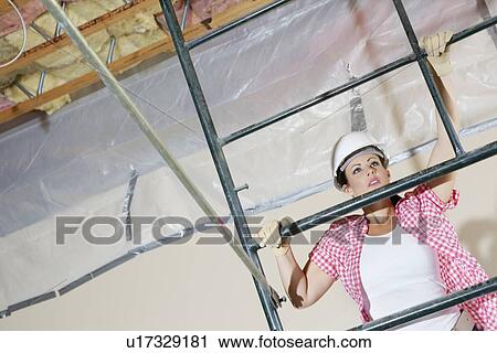 Young female construction worker climbing on scaffold View Large Photo Image Stock Image - Young female construction worker climbing on scaffold. Fotosearch