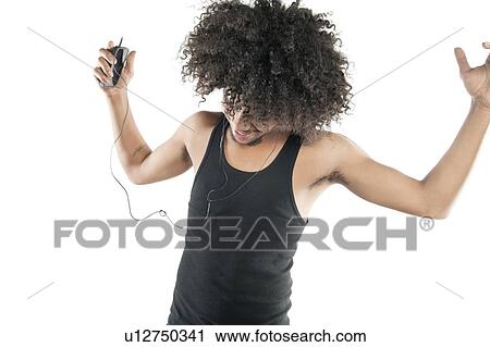 Young man with curly hair enjoying while listening to mp3 player over white background View Large Photo Image Stock Image - Young man with curly hair enjoying while listening to mp3 player over white background. Fotosearch