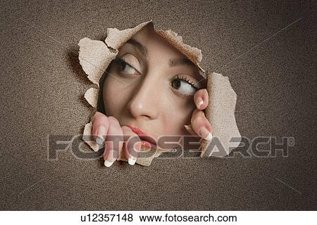 Young Middle eastern woman looking away from ripped paper hole View Large Photo Image Stock Photo - Young Middle eastern woman looking away from ripped paper hole. Fotosearch