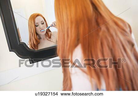 Young woman brushing teeth bathroom View Large Photo Image Picture - Young woman brushing teeth bathroom. Fotosearch
