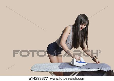 Young woman ironing shirt over colored background View Large Photo Image Stock Photo - Young woman ironing shirt over colored background. Fotosearch