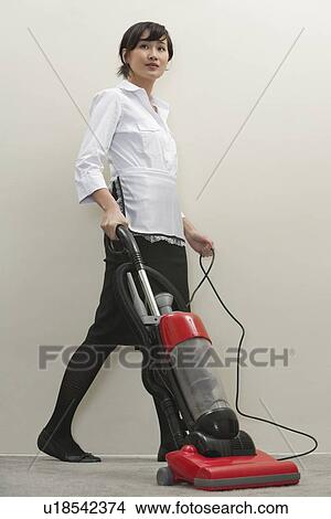丈いっぱいに の 若い 女性 家政婦 掃除機をかける ピクチャー U Fotosearch