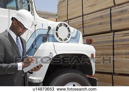 African American male contractor writing notes while standing by logging truck View Large Photo Image Stock Image - African American male contractor writing notes while standing by logging truck. Fotosearch