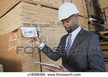 African American male contractor using tablet PC while inspecting wooden planks View Large Photo Image Stock Photography - African American male contractor using tablet PC while inspecting wooden planks. Fotosearch