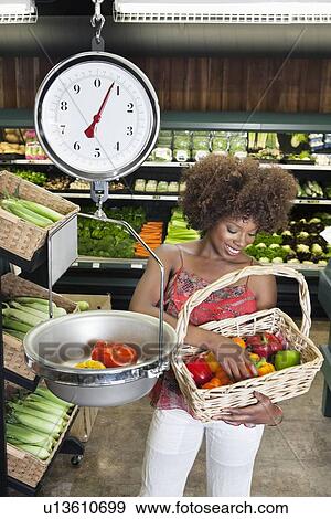 African American woman weighing bell peppers on scale at supermarket View Large Photo Image Stock Photo - African American woman weighing bell peppers on scale at supermarket. Fotosearch