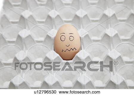 Stock Image - Anthropomorphic brown egg in empty carton. Fotosearch