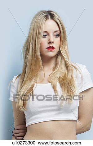 Beautiful blond woman with red lips looking down against light blue background View Large Photo Image Stock Image - Beautiful blond woman with red lips looking down against light blue background. Fotosearch