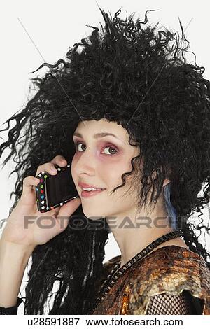 Beautiful young Goth woman with teased hair using mobile phone View Large Photo Image Stock Photo - Beautiful young Goth woman with teased hair using mobile phone. Fotosearch