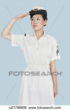 Stock Photo - Beautiful young US Navy officer saluting over light blue background. Fotosearch
