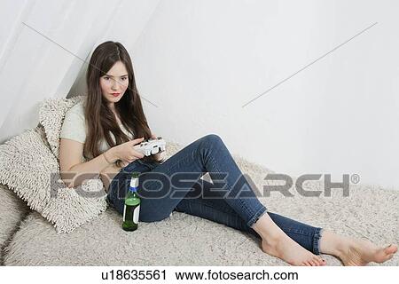 Beautiful young woman having beer while playing video game View Large Photo Image Stock Image - Beautiful young woman having beer while playing video game. Fotosearch