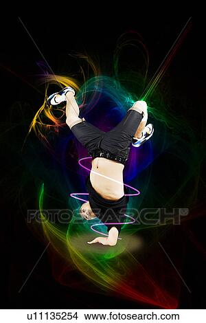 Picture - Break dancer on one arm over abstract background. Fotosearch