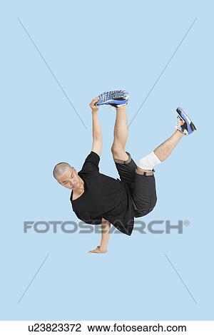 Break dancer performing handstand over blue background View Large Photo Image Stock Image - Break dancer performing handstand over blue background. Fotosearch