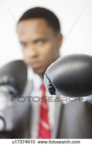 Businessman wearing boxing gloves with focus on gloves View Large Photo Image Stock Image - Businessman wearing boxing gloves with focus on gloves. Fotosearch