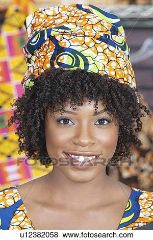 Stock Photo - Close-up portrait of an African American woman wearing traditional head wrap. Fotosearch