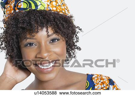 Stock Photo - Close-up portrait of an African American woman smiling over gray background. Fotosearch
