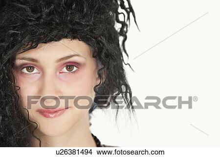 Close-up portrait of beautiful young woman with teased hair over gray background View Large Photo Image Picture - Close-up portrait of beautiful young woman with teased hair over gray background. Fotosearch
