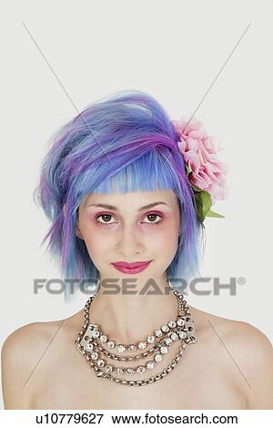 Stock Photo - Close-up portrait of beautiful young woman with flower in hair over gray background. Fotosearch