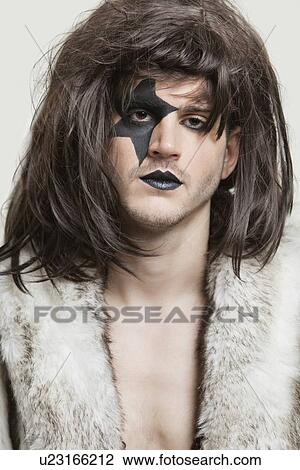 Close-up portrait of serious young man with painted face over gray background View Large Photo Image Stock Image - Close-up portrait of serious young man with painted face over gray background. Fotosearch
