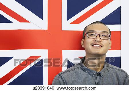 Stock Image - Contemplated man looking away while against British flag. Fotosearch