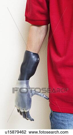 Stock Image - Cropped image of man with prosthetic hand over gray background. Fotosearch