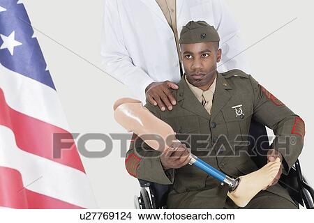 Doctor with disabled military officer holding artificial limb as he looks at American flag View Large Photo Image Picture - Doctor with disabled military officer holding artificial limb as he looks at American flag. Fotosearch