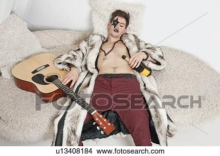 Drunk young man with guitar sleeping on sofa View Large Photo Image Picture - Drunk young man with guitar sleeping on sofa. Fotosearch