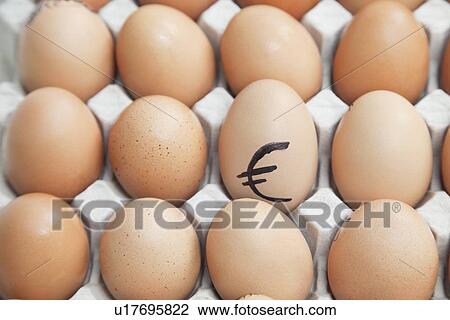 Stock Image - Euro sign on egg surrounded by plain brown eggs in carton. Fotosearch